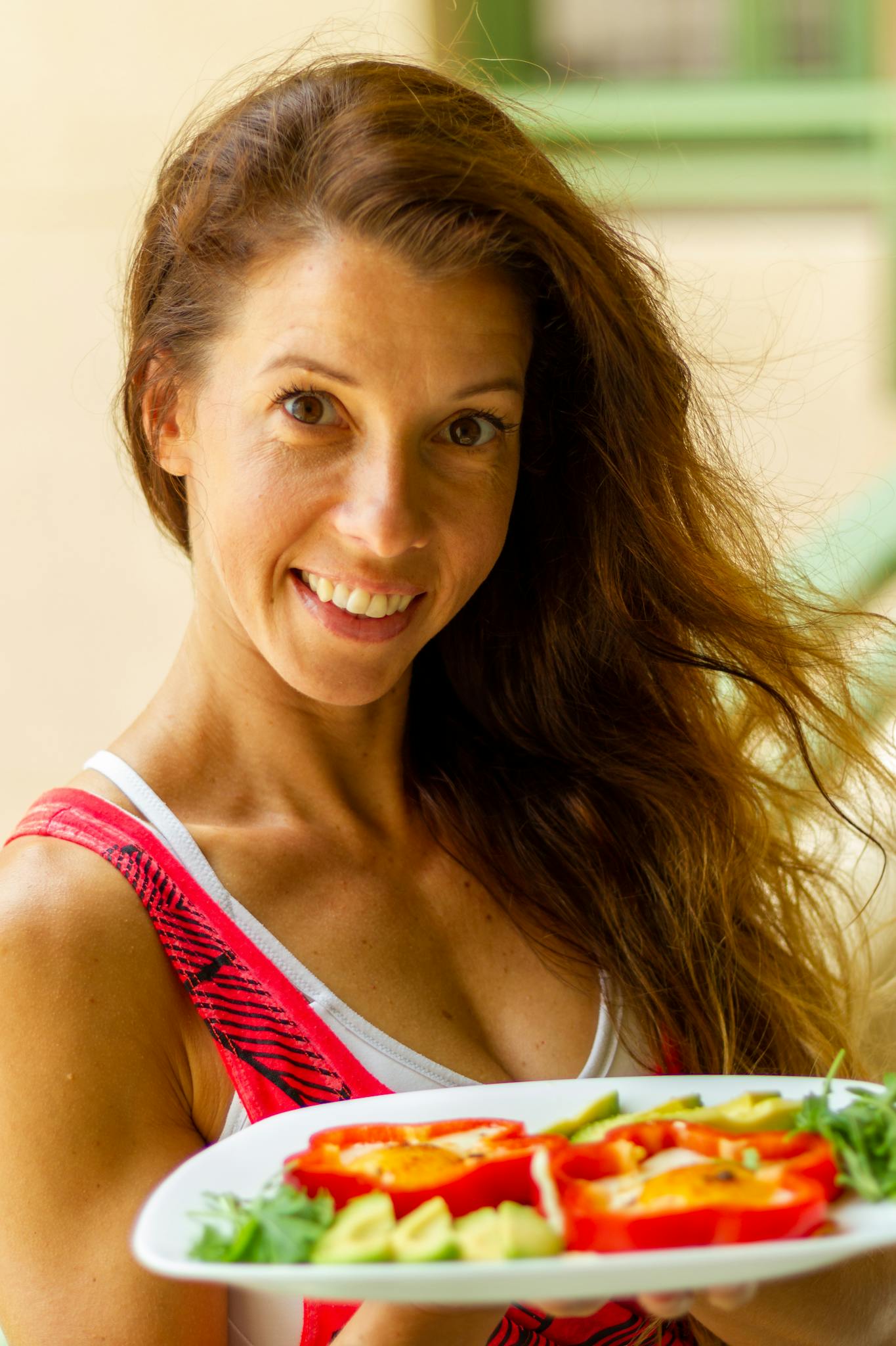 Bright portrait of a woman showcasing a healthy vegetable salad, perfect for lifestyle and nutrition themes.